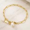 pulsera-con-perla-y-dijes-B02378G-color-dorado-en-acero-inoxidable Pulsera perlas y dijes en eslabones con enchape de oro 18k