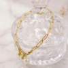 pulsera-de-perla-y-dijes-con-eslabones-dorados-en-acero-inoxidable Pulseras en perla y dijes con eslabones dorados en acero inoxidable y enchape de oro de 18k