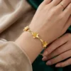 Pulseras para mujeres diseño flexible tipo malla adornada con apliques florales de acero y bañada en oro 18k
